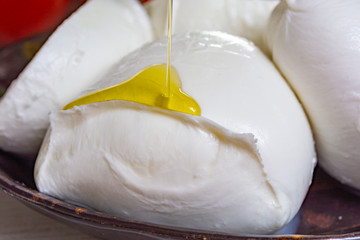 Balls and pieces of buffalo mozzarella, soft Italian scheese made from the milk of Italian Mediterranean buffalo