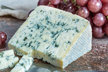 Blue Auvergne semi-hard AOP French blue cheese made from raw cow milk in Auvergne, France served as dessert with grapes