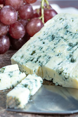 Blue Auvergne semi-hard AOP French blue cheese made from raw cow milk in Auvergne, France served as dessert with grapes