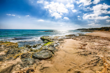 Picturesque seascape with white rocky cliffs, sea bay, islets and faraglioni near by Frassanito Beach,