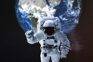 Fototapeta na wymiar Astronaut in a front of Earth planet of solar system. Science fiction. Elements of the image were furnished by NASA