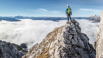 Mountaineer standing on a rock high up on the mountain
