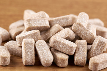 Many brown pills on wooden background. Tablets and medicine