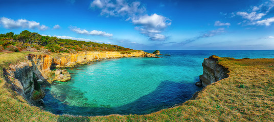 Fototapeta premium Picturesque seascape with white rocky cliffs, sea bay, islets and faraglioni near by beach Spiaggia della Punticeddha