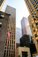 New york, usa- August 13, 2008: Vertical image of condensed and cramped American skyscrapers, with American flag attached to a facade.