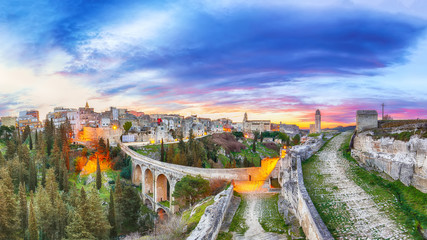 Naklejka premium Gravina in Puglia ancient town, bridge and canyon at sunrise