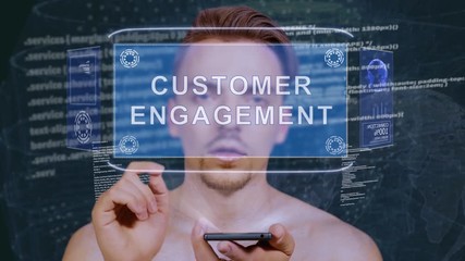 Young man interacts with a conceptual HUD hologram with text Customer engagement. Guy with future technology mobile screen on background of the program code - Powered by Adobe