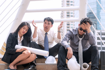 Group architect or business people feeling tired and headache with their job. sitting on stairs...