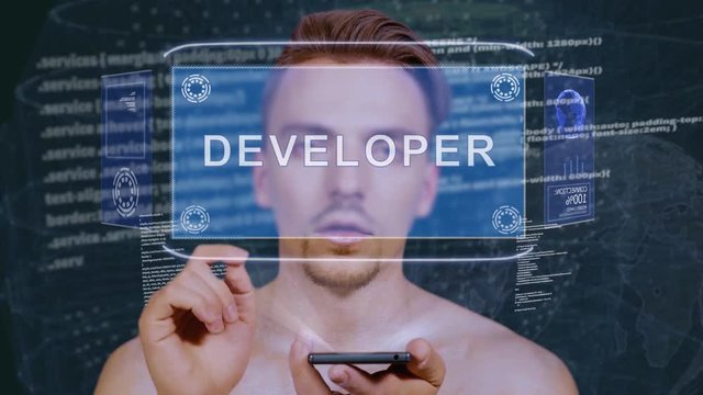 Young man interacts with a conceptual HUD hologram with text Developer. Guy with future technology mobile screen on background of the program code