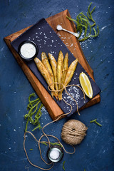 Fish and chip, traditional english seafood snack, tartar souce and lemon.