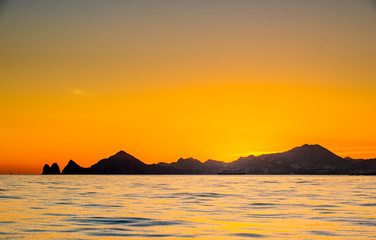 Naklejka na ściany i meble Beautiful Sunset of Seascape with Mountains silhouets. Sea off the Coast of Cabo San Lucas. Gulf of California (also known as the Sea of Cortez, Sea of Cortes. Mexico. Sunset over Cabo San Lucas.