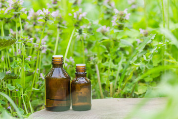 pharmaceutical bottle of medicine from Thymus vulgaris, common thyme, German, garden or just thyme on a wooden table. Preparation of medicinal plants. Ready potion of grass. Ethnoscience.