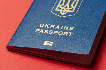 Ukrainian international biometric passport at red paper background. Documents for vacations.