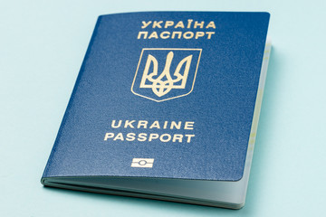 Ukrainian international biometric passport at light blue background. Documents for vacations.