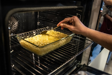 Chef preparing a roast of vegetables in an oven.
