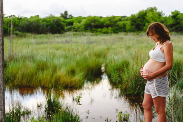 Pregnant woman relaxing looking at the landscape of a lake.