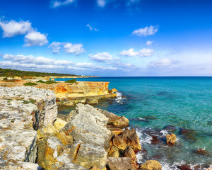 Fototapeta na wymiar Picturesque seascape with white rocky cliffs, sea bay, islets and faraglioni near by Conca Specchiulla Beach