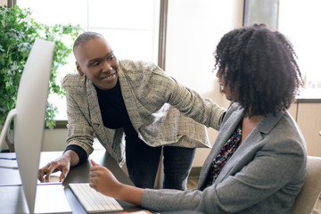 Black African American businesswomen or coworkers together in an office doing teamwork or job...