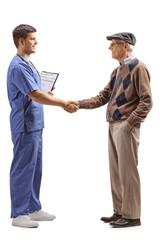 Male doctor in a blue uniform shaking hands with a senior man