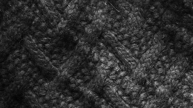 Black wool, weaving pullover background waving. Close up, macro shot of vintage winter fabric cloth.