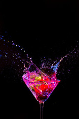 Strawberry in Whine Glass Along With Droplets Colorful Liquid. Isolated Over Black.