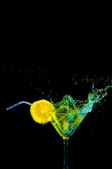 Fast Moving Droplets of Liquid in Wineglass with Slice of Lemon and Straw. Isolated Over Black.