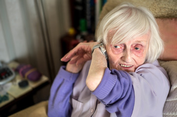Blind,elderly woman listens to talking wrist watch,England,U.K.
