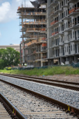 Fototapeta na wymiar Railroad tracks with city construction in background