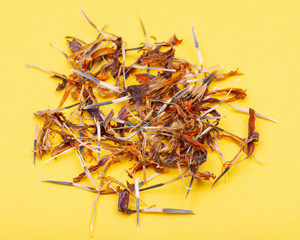 Pile of Marigold Dry Seeds (Mexican marigold, Aztec marigold, African marigold) on yellow background. Tagetes erecta. Daisy family.