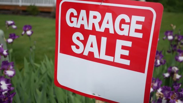 Garage sale sign in garden in front yard
