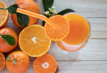 Fresh oranges and a glass of orange juice on wooden table