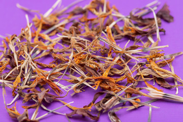 Pile of Marigold Dry Seeds (Mexican marigold, Aztec marigold, African marigold) on purple background. Tagetes erecta. Daisy family.