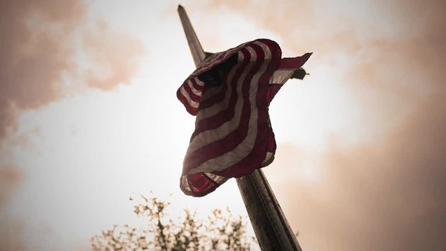 Cinematic flag raised half way up with sun background - sepia cinematic version