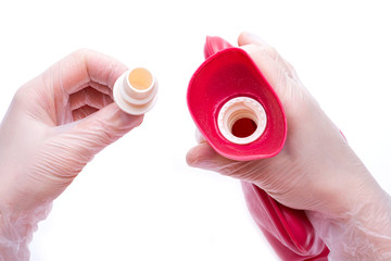 Nurse wearing sterile rubber gloves holds Reusable Rubber Hot Water Bottle- Classic, Large ½ Gallon Red Bag for Hot or Cold Therapy. 