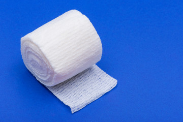Hospital Grade Sterile White Rolled Gauze on blue background.