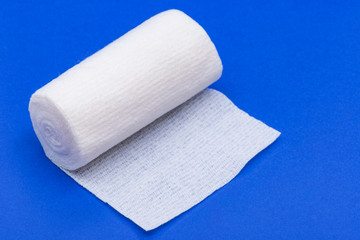 Hospital Grade Sterile White Rolled Gauze on blue background.