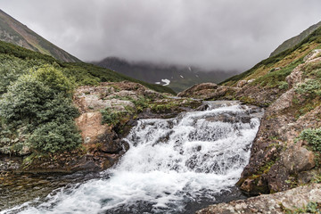 Mountain landscape of Kamchatka: beautiful waterfall. Summer landscape of Kamchatka