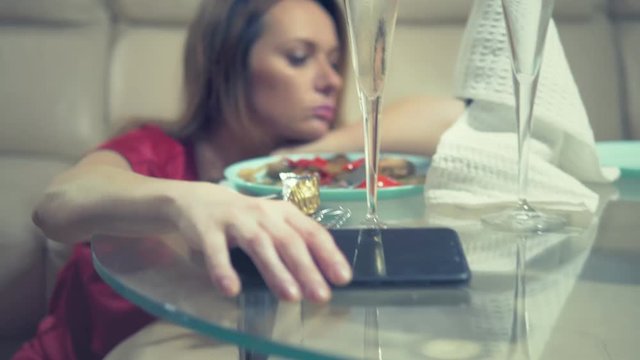woman gets drunk at home alone at a table set for two for a romantic date, as her partner did not come on a date