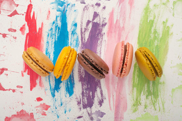 Lots of macarons colored on a color watercolor bright background. Confectionery art concept....