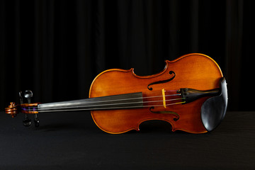 Close-up of wooden violin, stringed instrument with black background 