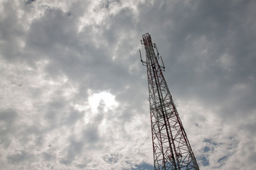 Telecommunication tower radio signal on cloudy background.