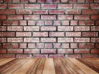 Wooden table top over vintage brick wall texture and background..