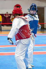 Fototapeta premium two girls in blue and red Taekwondo equipment are fighting at doyang