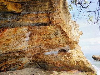 Beautiful single rock formation on the seashore with silky smooth water reflection background.