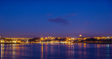 Fototapeta na wymiar Iluminated Porto city with moon above it, Porto, Portugal.