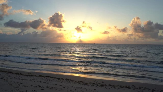 El mar est&aacute; tranquilo a la hora del atardecer y aparece una mujer trotando.