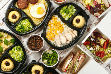 Containers with delicious food on table