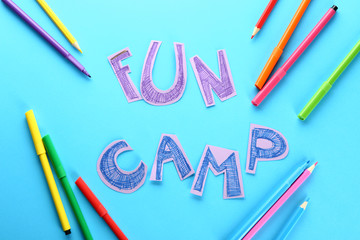 Felt-tip pens, pencils and text FUN CAMP on color background