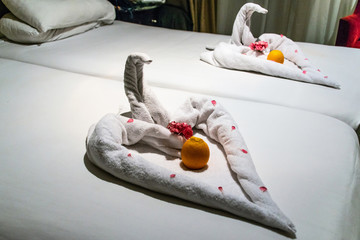 vacation decorative close up a animal made of white towel lies on a bed in Egypt nile cruise boat hotel in Africa