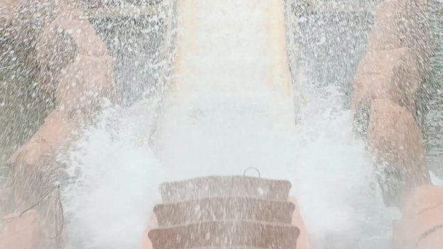 Slow motion of water roller coaster ride coming down splashing water.